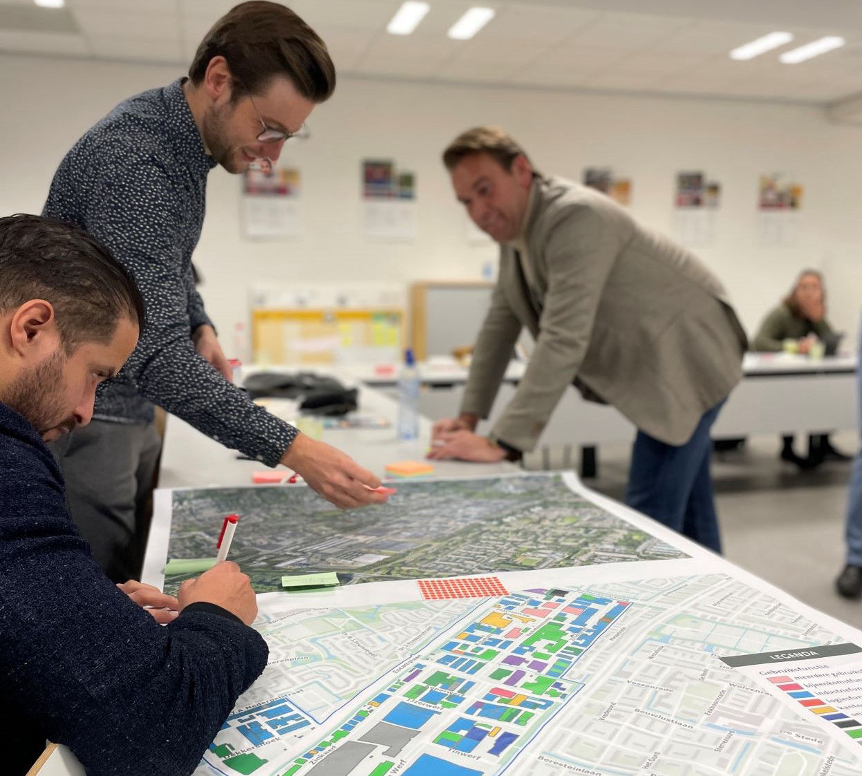 Twee deelnemers plakken post-its op een geprinte kaart van het ZKB-gebied